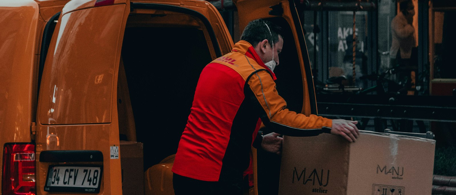 Driver loading parcels into a delivery van